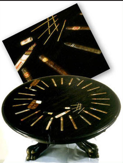 A photo of a hand painted coffee table that has images of cigars painted on it.