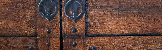 A detail photo of vinyl garage doors I painted to look like real wood with old cast iron hardware.