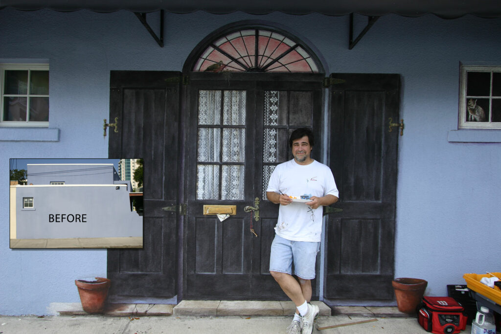 Photo of a mural I painted on an exterior stucco wall in Sarasota, FL. I painted images of two balck doors with lace curtains and black shutters