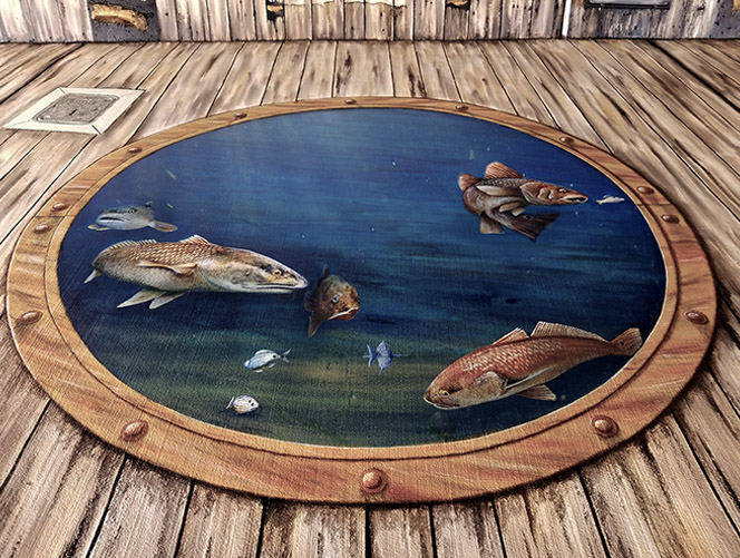 A photo of a potion of a mural I painted under a bridge in Punta Gorda, FL that depicts a series of portholes set into what appears to be old wood. Through each porthole can be seen different species of fish.