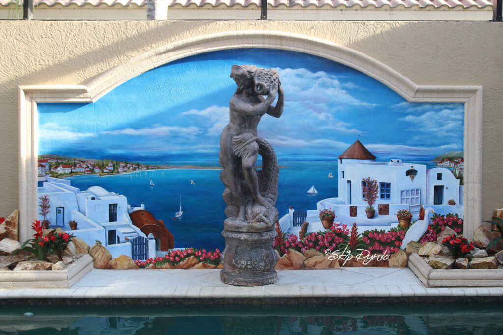 Photo of a pool-side mural in Sarasota, FL. Painted by Skip Dyrda to look similar to Santorini, Greece