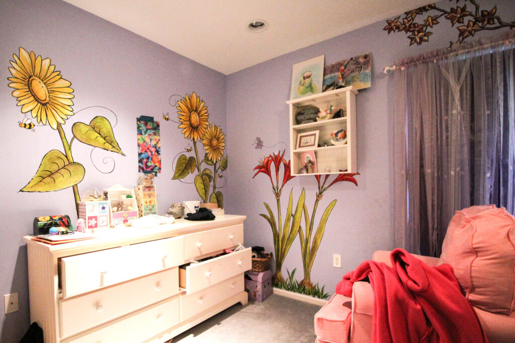Photo of a young ladies bedroom where I painted flowers, trees, bumblebees and a tree.