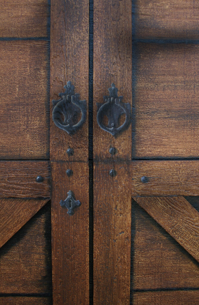 A photo of a garage door that I painted to look like old and weather wood with castiron hardware