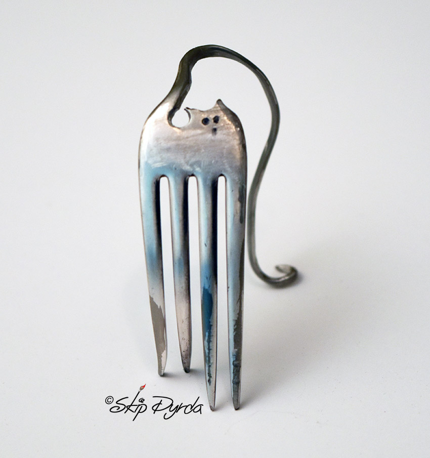 A photo of a cat, made from a stainless steel fork