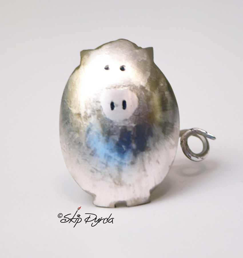 A photo of a pig made from a stainless steel spoon.