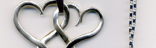 A photo of a pendent of two intertwined hearts, made from a silver plated fork