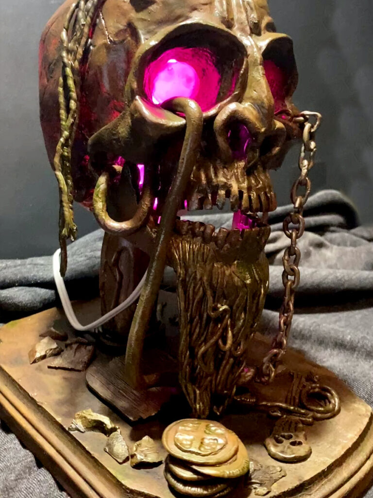 A photo of a pirate skull lamp that I created out of plastic clay and various found parts.