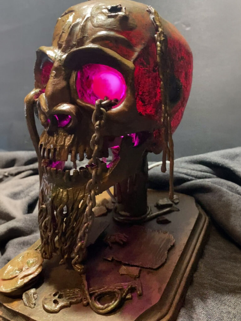 A photo of a pirate skull lamp that I created out of plastic clay and various found parts.