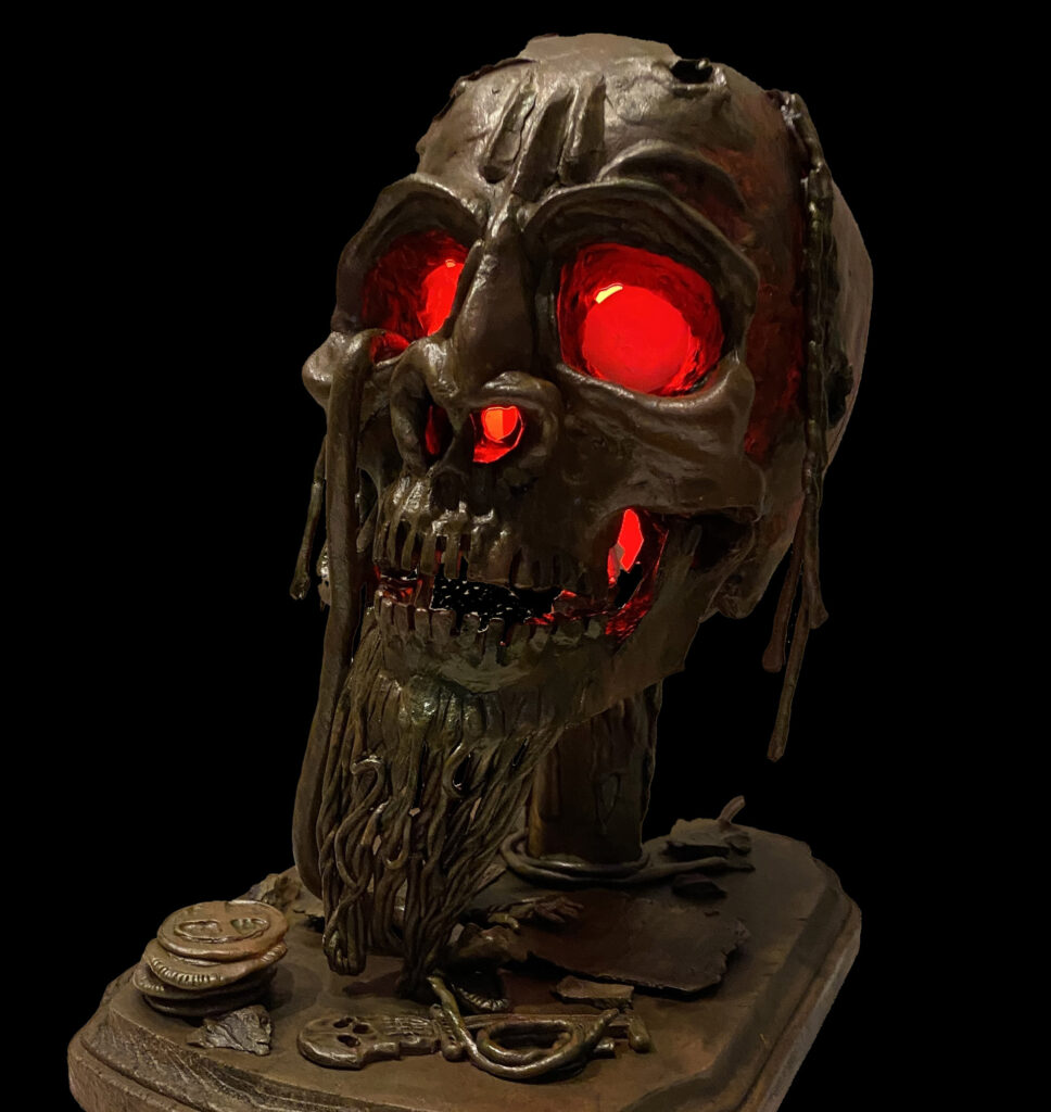 A photo of a pirate skull lamp that I created out of plastic clay and various found parts.