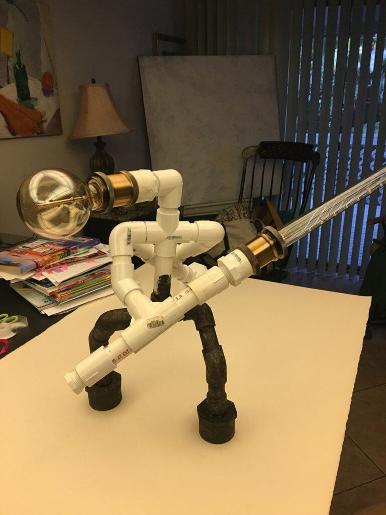 Custom made tablelamp, made to look like a fighting robot made of waterpipe