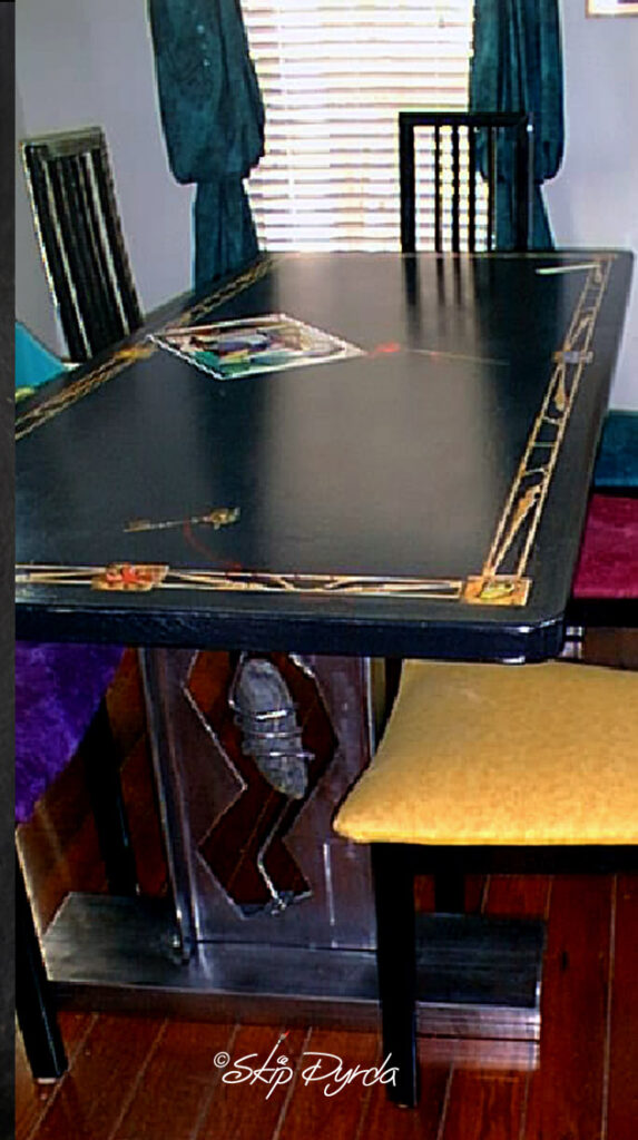 A detail photo of a dining room table I made. This shows some Trompe L'oeil elements...a Picasso poster and paint brush with splattered paint